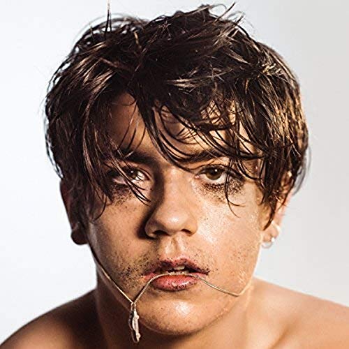 Close-up portrait of Declan McKenna with smeared makeup and a necklace.