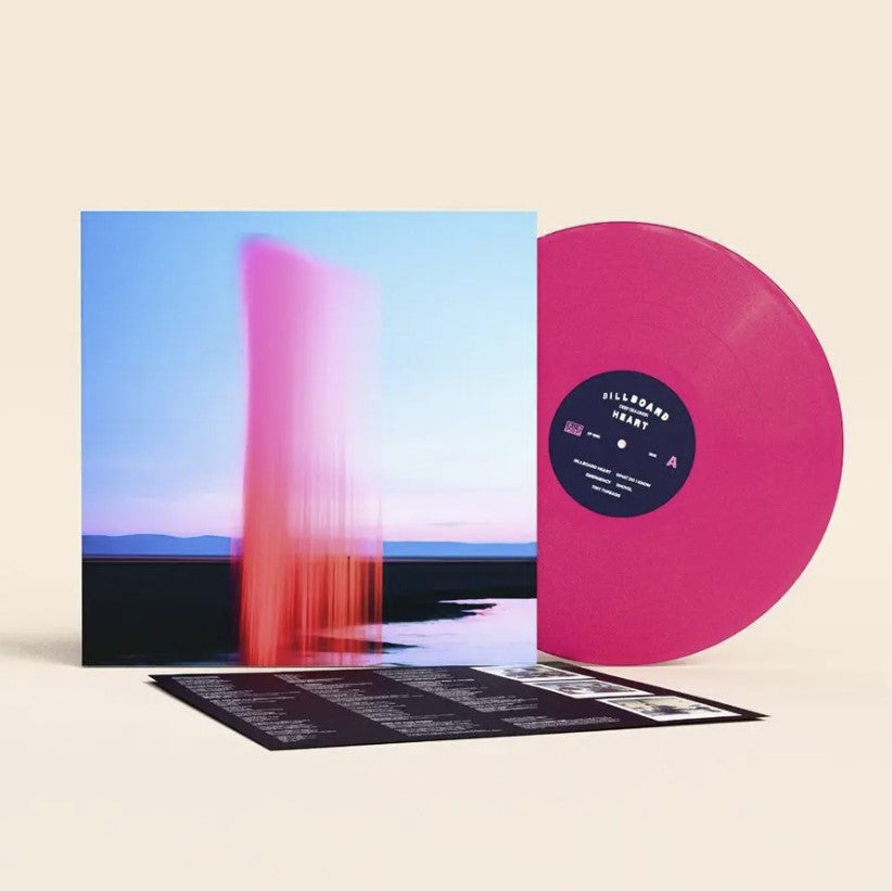 Pink vertical light streaks over a blurred landscape and water.