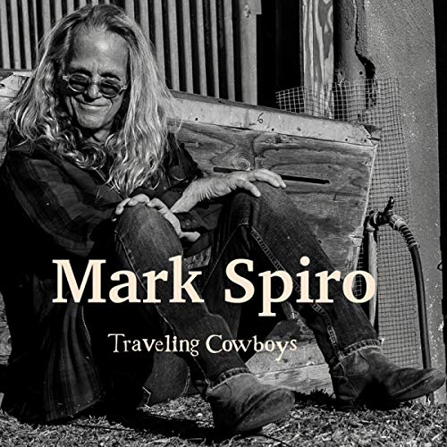 CD cover: Mark Spiro, a man with long hair, sitting on a trunk.