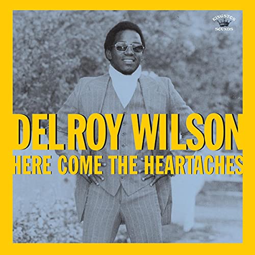 Delroy Wilson album cover, portrait of a man in a suit and sunglasses.