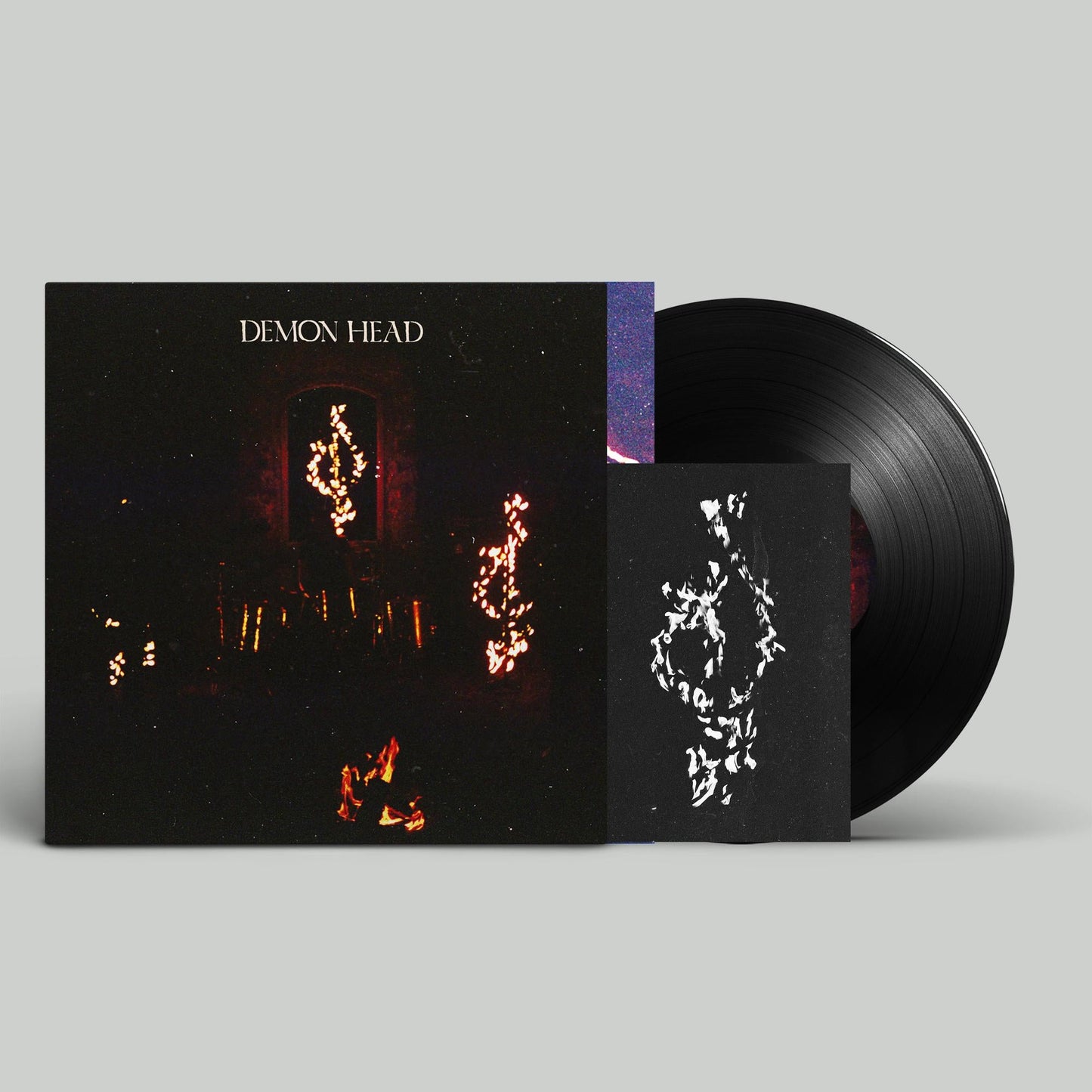Vinyl record and cover art featuring a dark, starry, demonic image.
