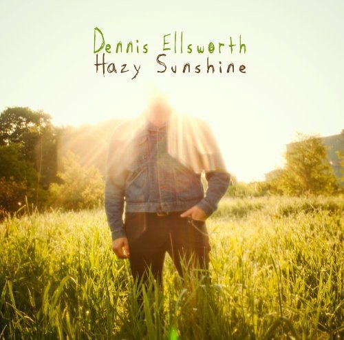 A man stands in a field with sunlight shining behind him, obscuring his face.