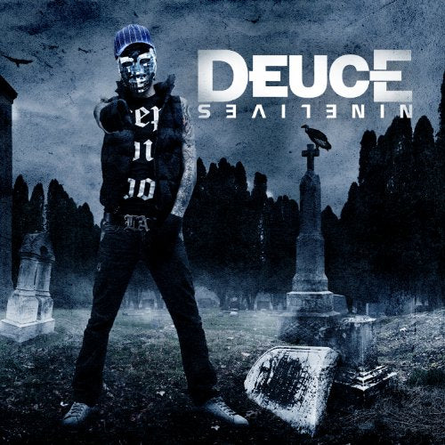 Rapper Deuce stands in a graveyard with tombstones and crows.