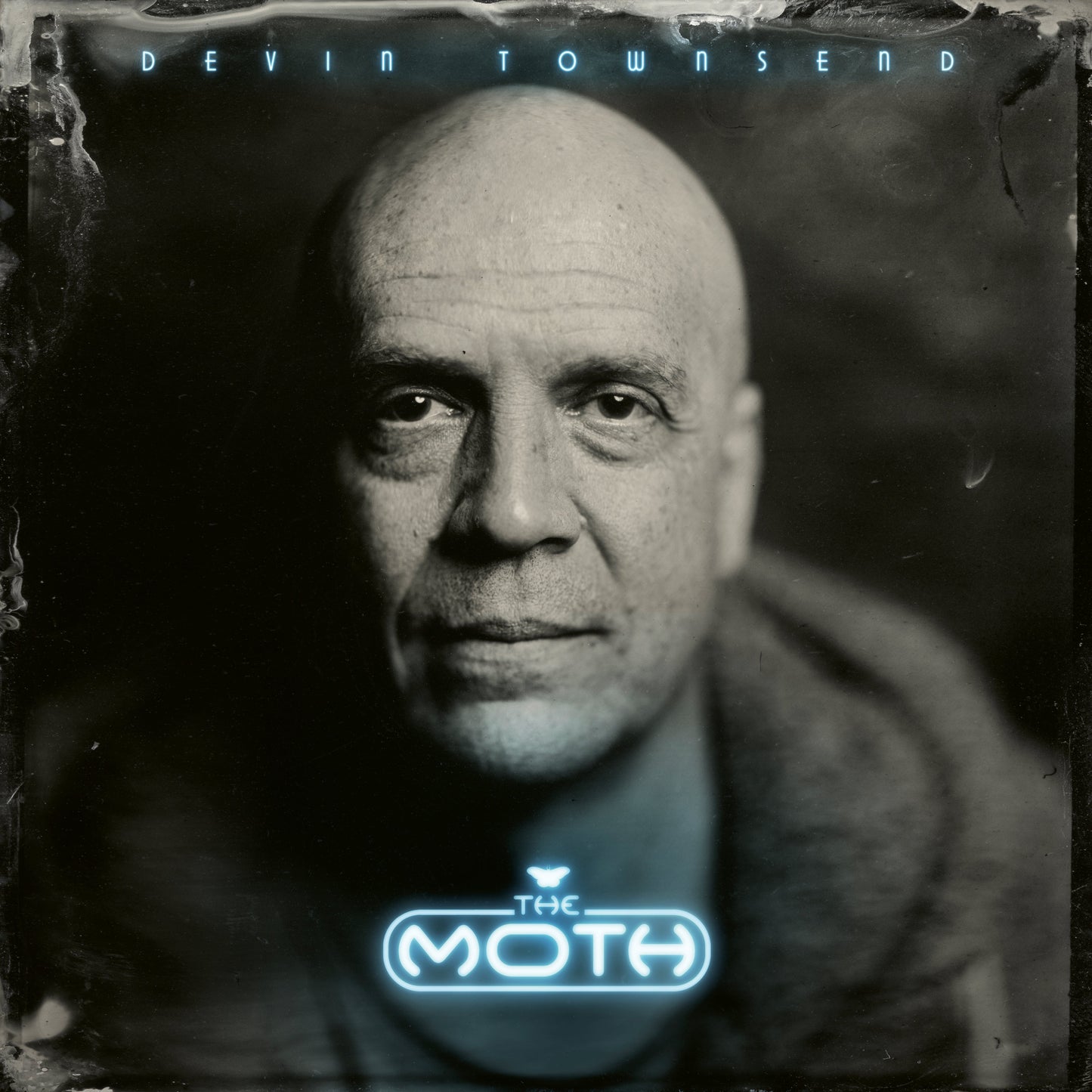 Black and white close-up of a bald man with text overlay reading Devin Townsend The Moth.