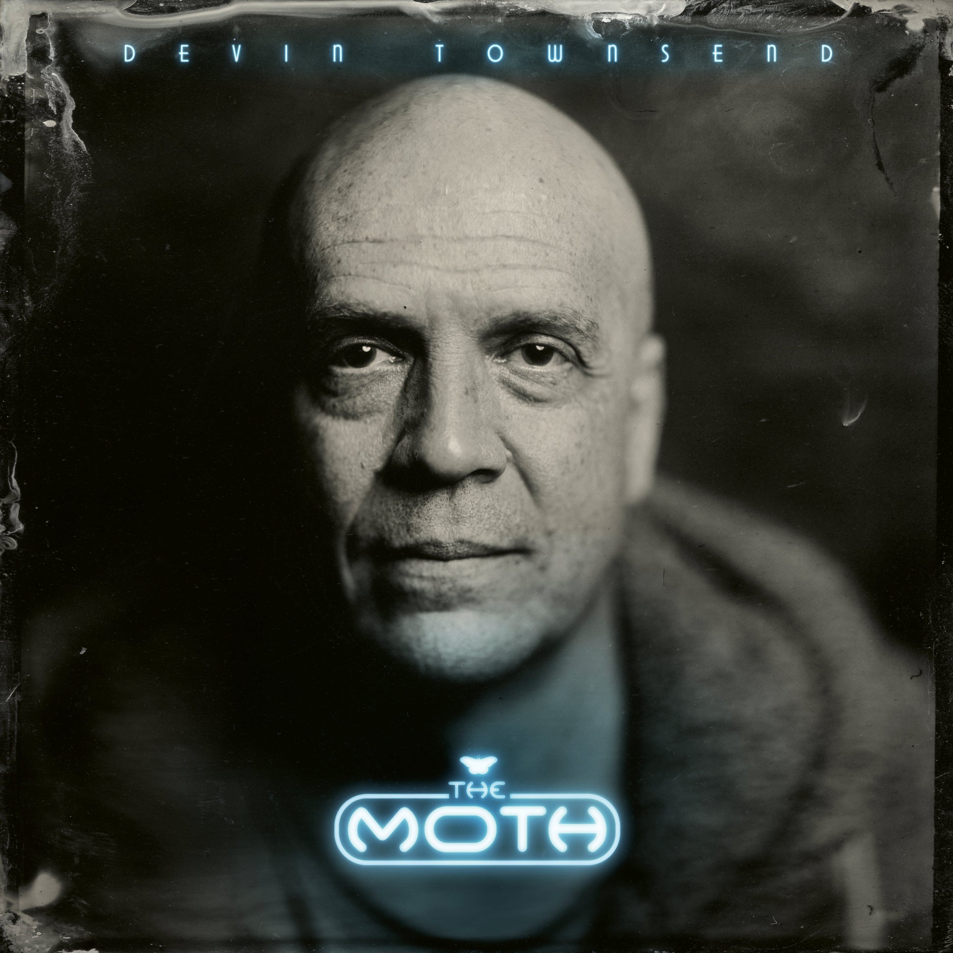 Black and white close-up of a bald man with text overlay reading Devin Townsend The Moth.