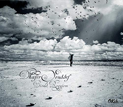 CD cover: lone figure on a beach under a cloudy, bird-filled sky.
