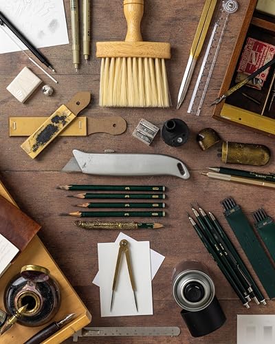 Flat lay of various artist drawing tools arranged on a wooden surface.
