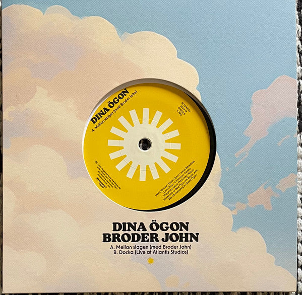 Vinyl record label with yellow sunburst design and blue sky background.