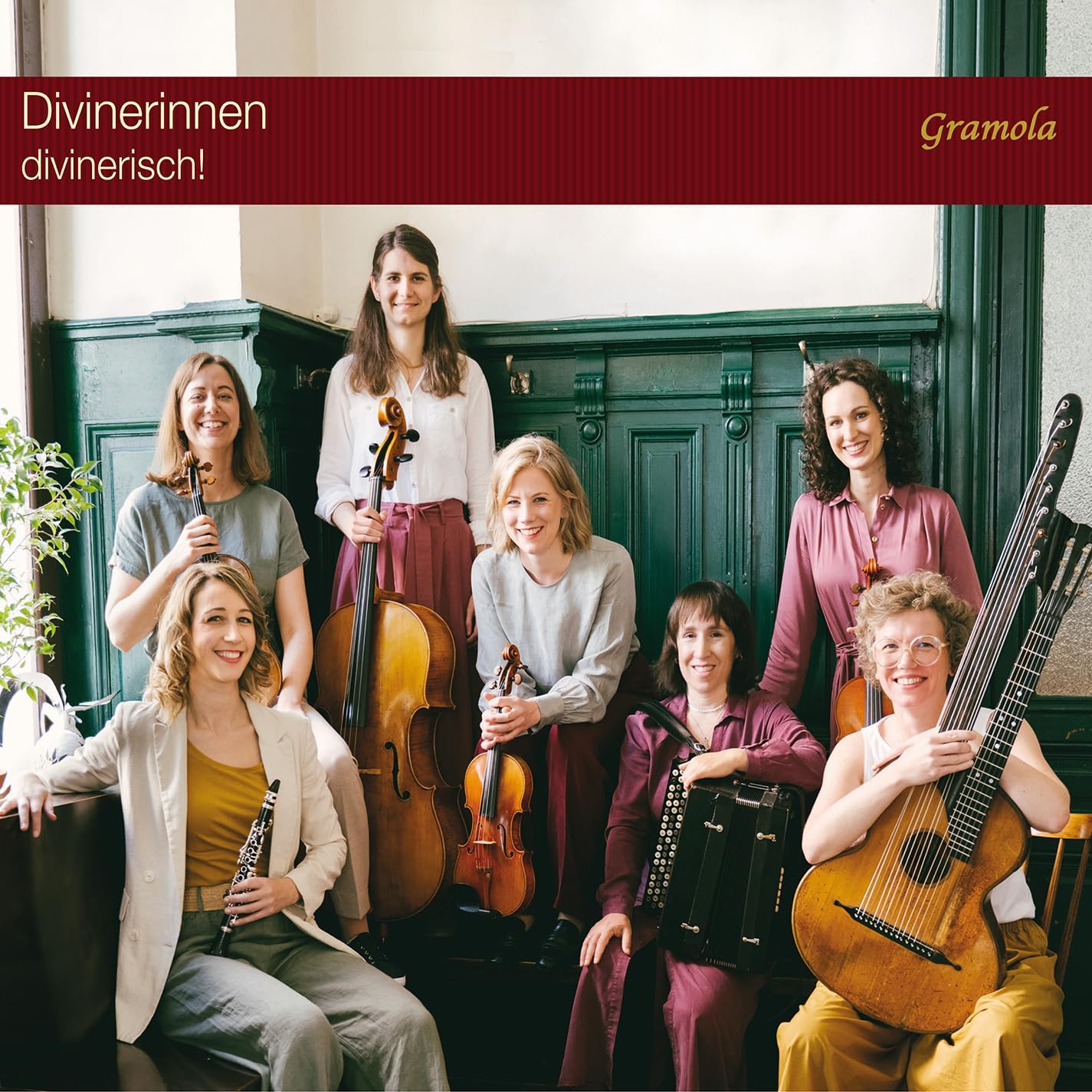Seven female musicians pose with various acoustic instruments in front of a green wall.