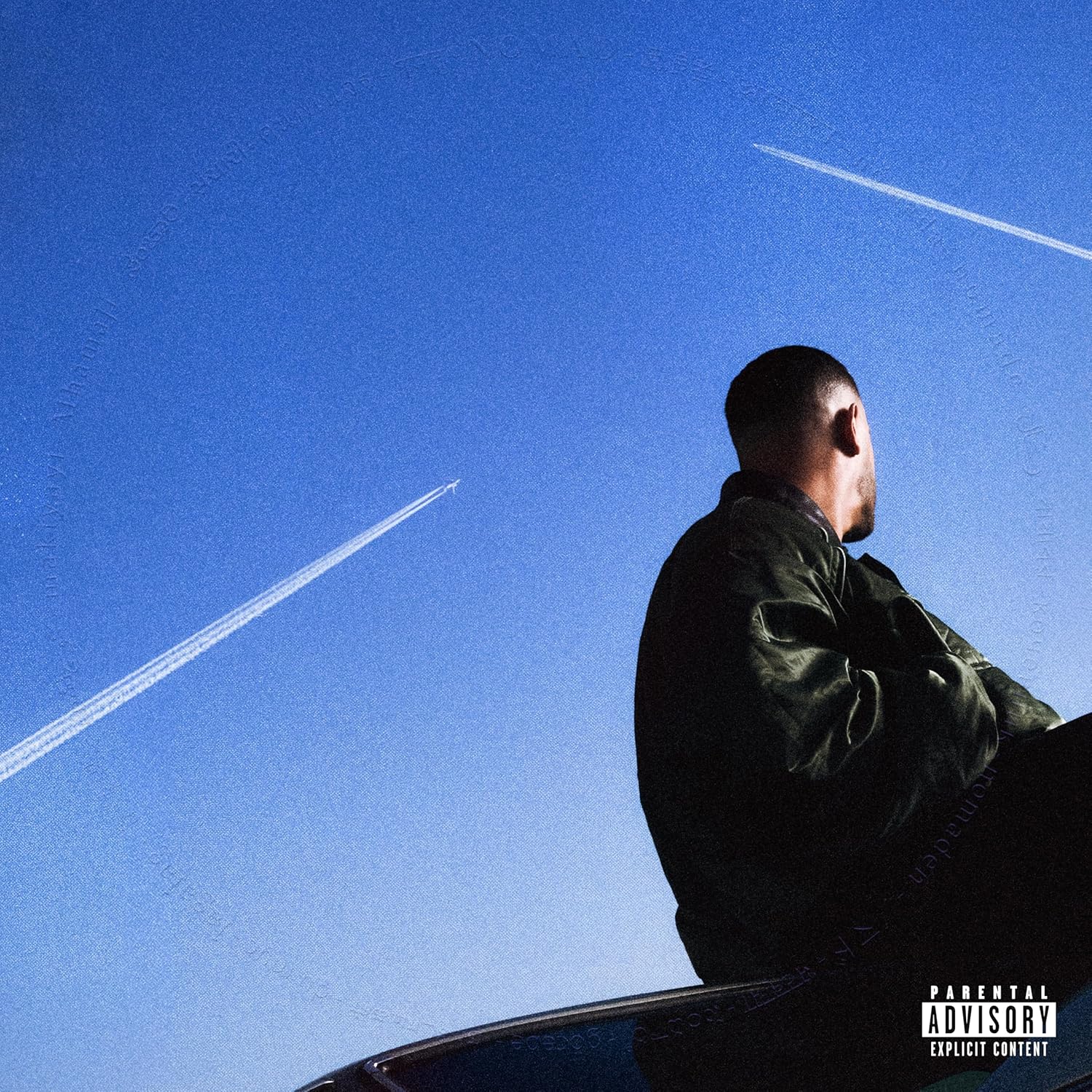 DJ Snake album cover: man looking up at contrails in blue sky.
