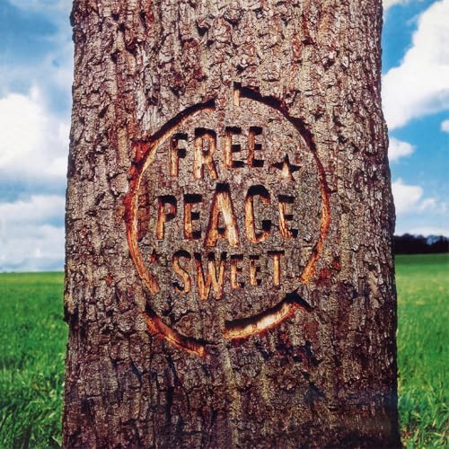 The words Free Peace Sweet carved into the bark of a tree trunk.