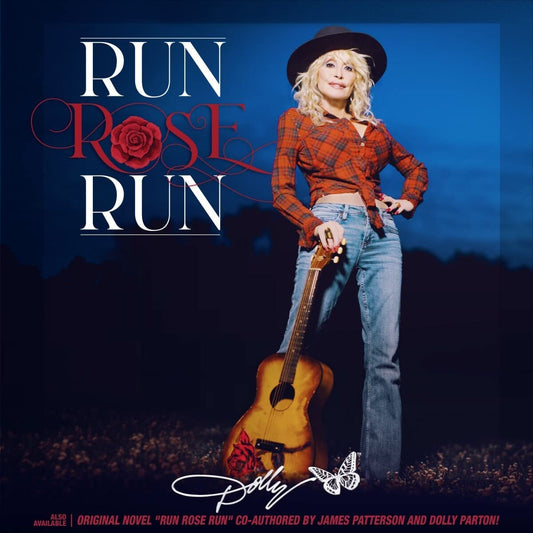 Dolly Parton stands holding a guitar, wearing a hat and red plaid shirt.