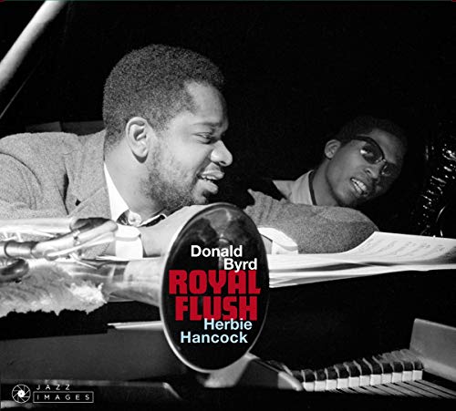 Donald Byrd playing trumpet, Herbie Hancock visible in background, black and white photo.