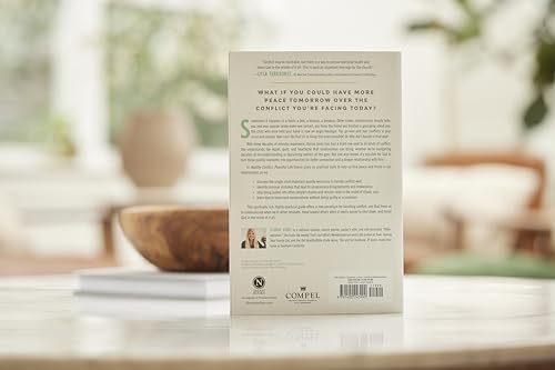 Book cover with text, placed on a reflective table with decor.