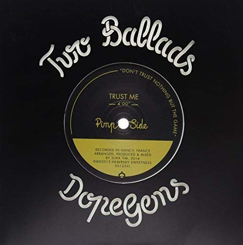 Vinyl record with "Trust Me" label, black and gold design, on a dark background.