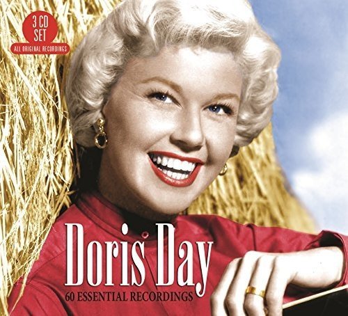 Doris Day smiling in a red shirt in front of a haystack.