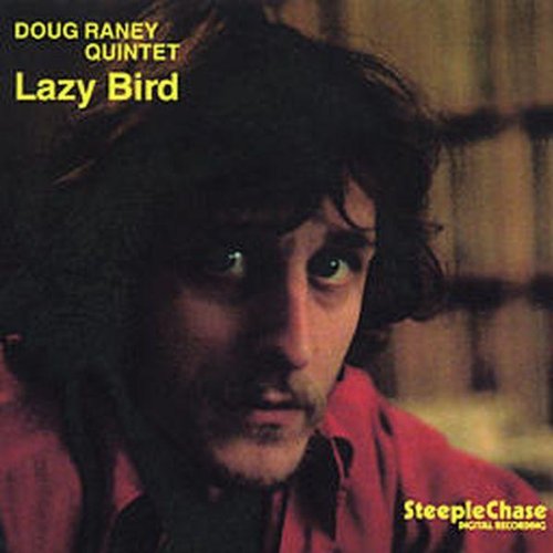 "Album cover featuring a man with dark hair and a red shirt, with yellow text."
