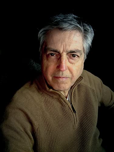 Close-up portrait of a man with gray hair and a brown sweater.