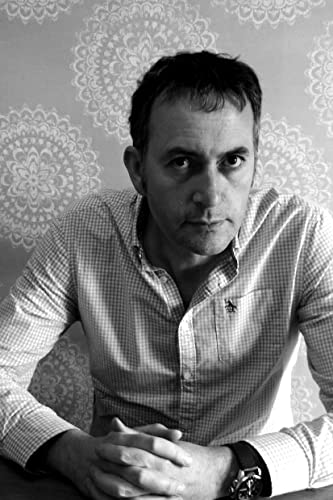 Black and white portrait of a man with short hair and a checkered shirt.