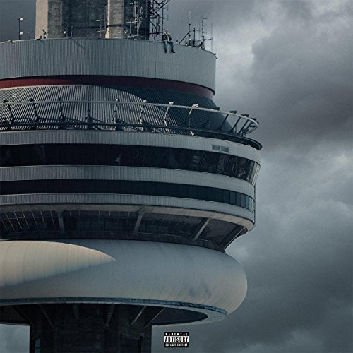 A person sits on the edge of the CN Tower against a cloudy sky.