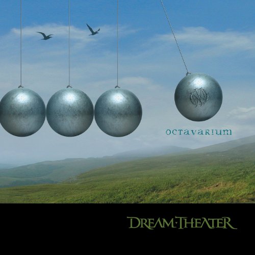 "Four metal spheres suspended from strings against a green hillside and blue sky."