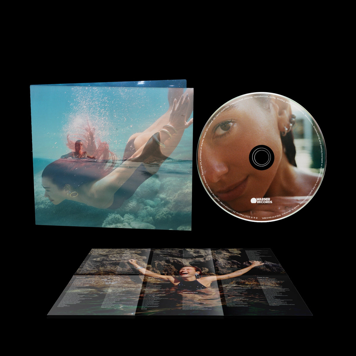 Dua Lipa “Radical Optimism” CD case with shark and ocean imagery.