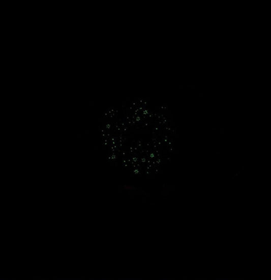 Black background with a cluster of small, green, sparkling dots.