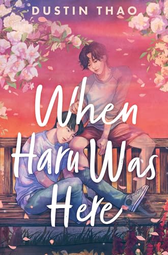 Two young men sit together on a wooden bench amidst falling cherry blossoms.