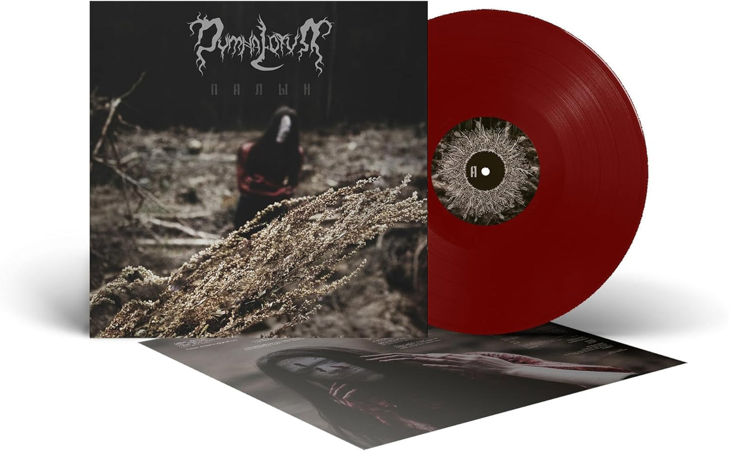 Vinyl record with dark album art featuring a figure and foliage.