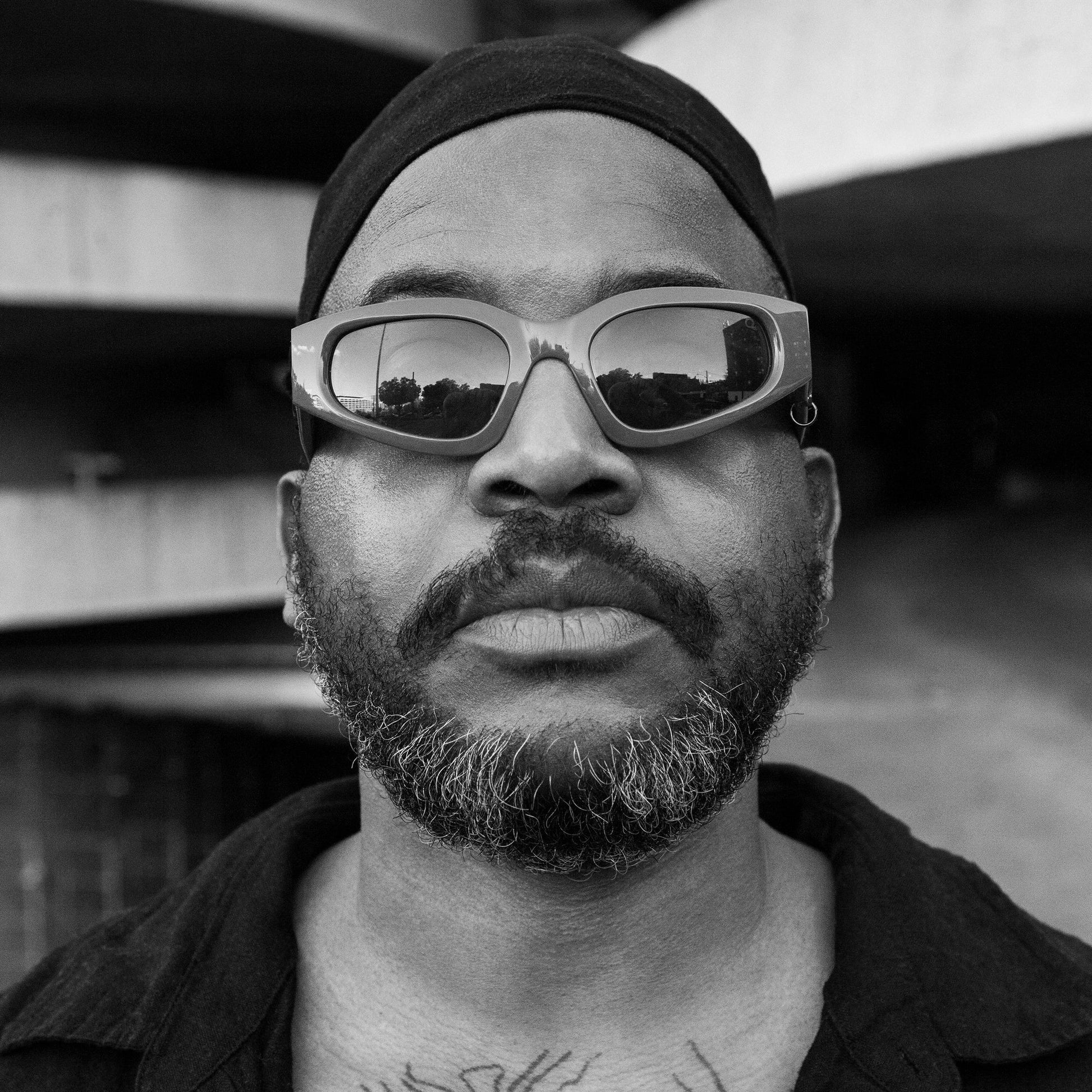 Black and white portrait of Elucid wearing sunglasses and a do-rag.