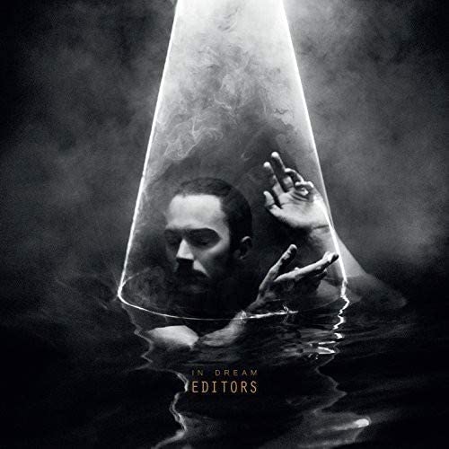 Black and white album cover: man submerged, reaching under a light cone.