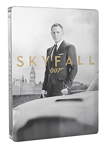 Man in suit standing beside a car with a cityscape and clock tower behind him.