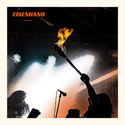 Silhouetted figures on stage with one person holding a flaming torch against bright lights.