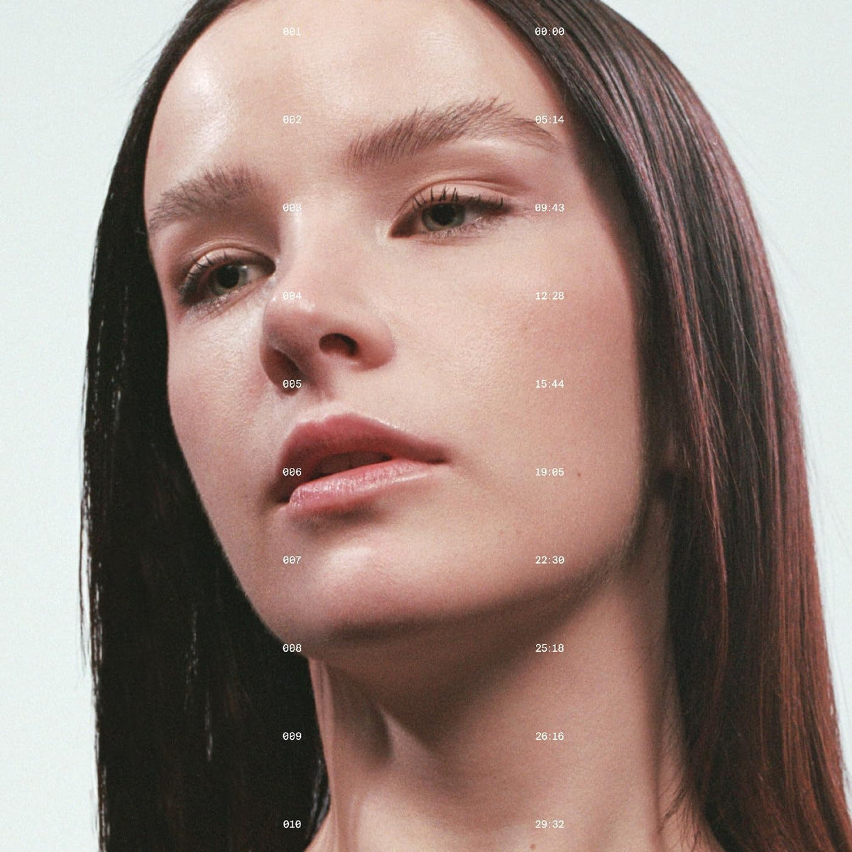 Close-up portrait of a woman with timecode numbers overlaid on her face.