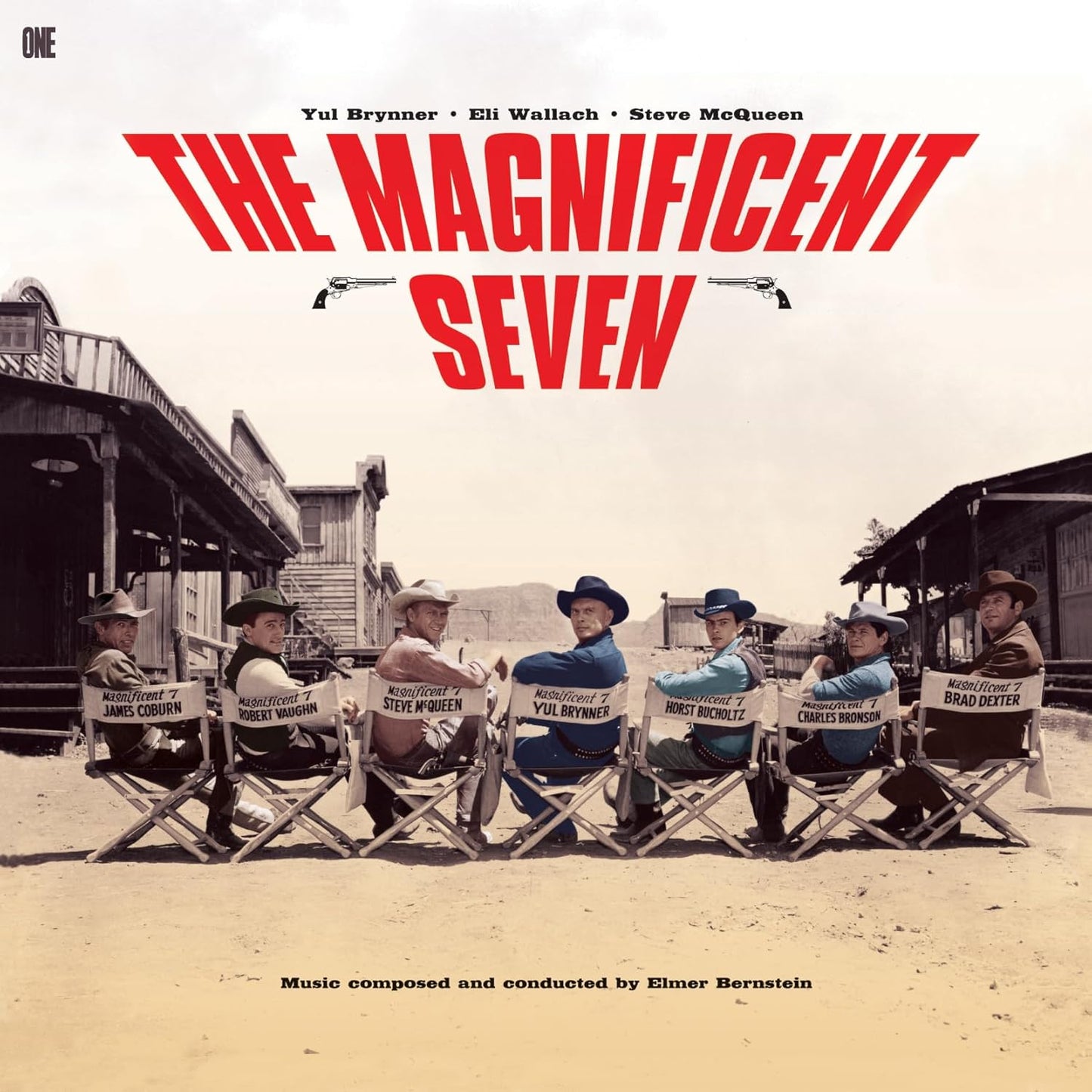 Seven actors sit in director chairs on a dusty movie set for The Magnificent Seven.