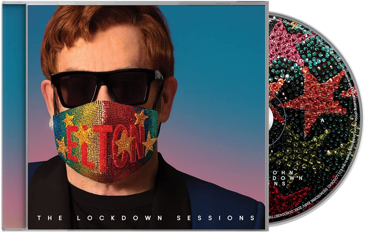 Elton John wearing sunglasses and a rainbow face mask with his name on it.