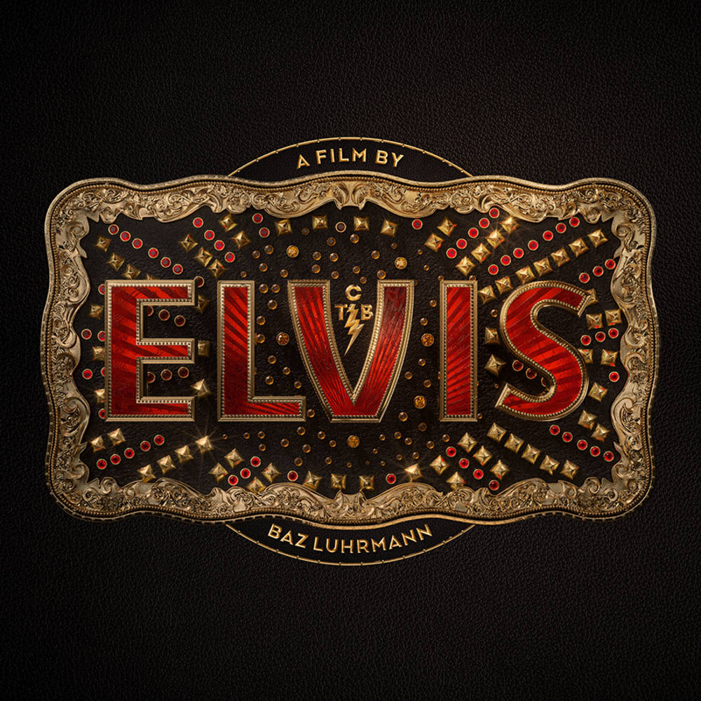 Gold belt buckle with red Elvis logo on black background with gold text.