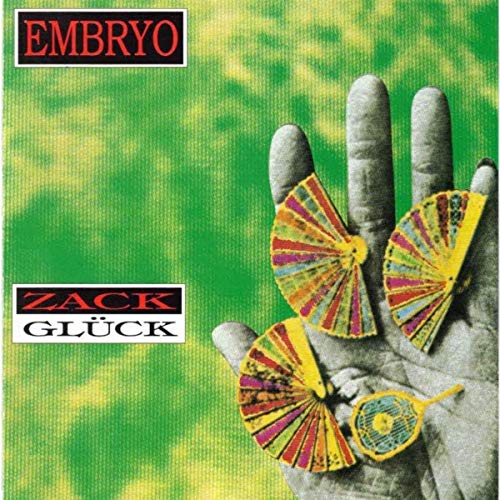 Hand holding colorful, open fans against a textured green background.