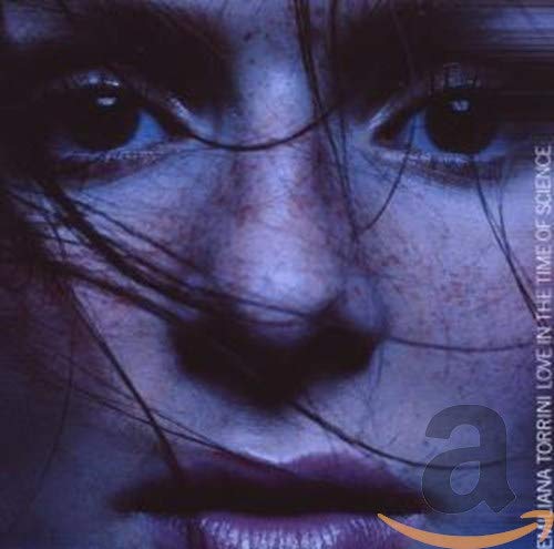 Close-up of a woman’s face with dark hair, album cover art.