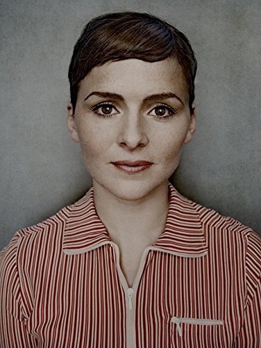 Close-up portrait of Emiliana Torrini with short brown hair and a striped shirt.
