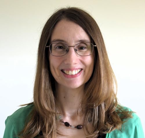 Headshot of smiling woman with brown hair and glasses.