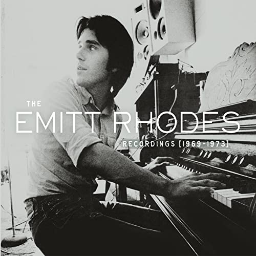 Black and white photo of Emitt Rhodes playing a piano in a studio setting.