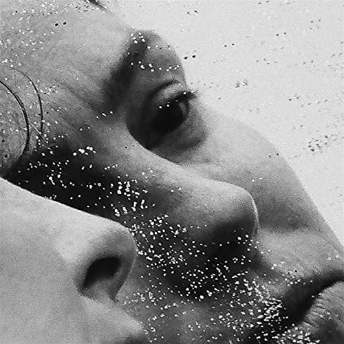 Black and white close-up of a face with water droplet texture.