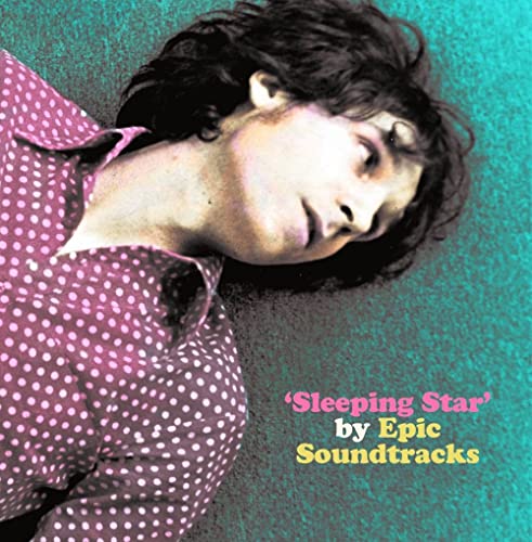 A person in a polka-dot shirt lying on a teal background.