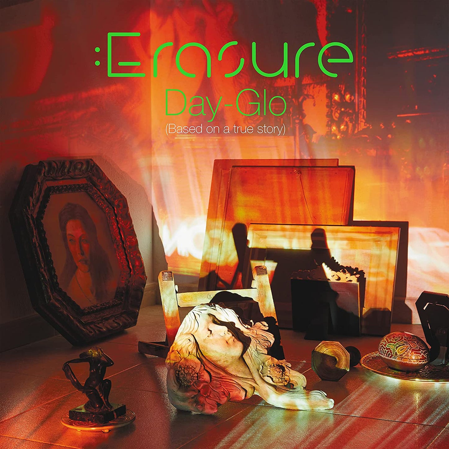 "CD case with red cover and green CD, titled 'Erasure Day-Glo', on grey background."