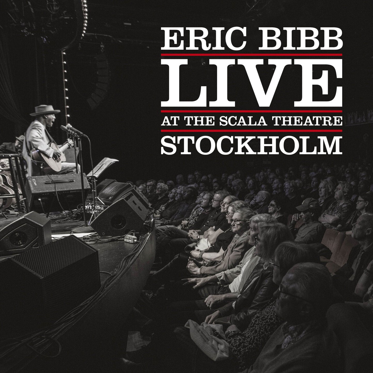 Eric Bibb performing live on stage with an audience in Stockholm.