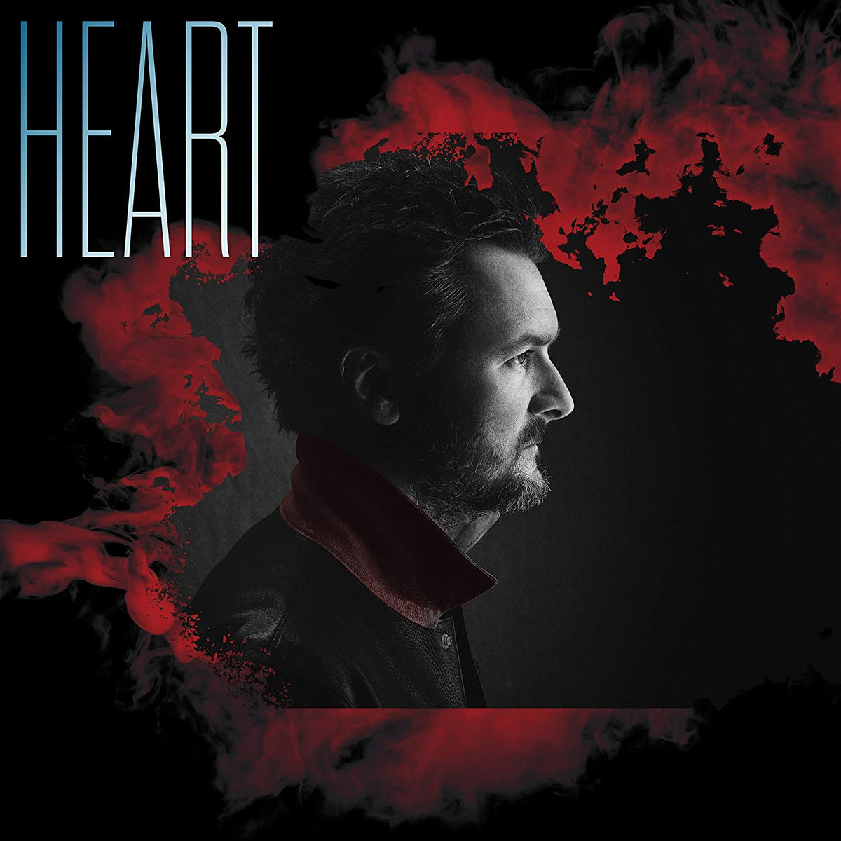 Profile portrait of Eric Church against a black background with red smoke effects.