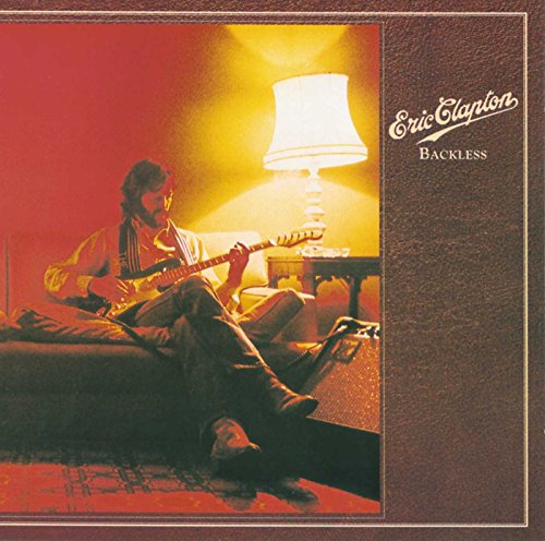 Eric Clapton playing guitar, seated near a lamp, album cover art.