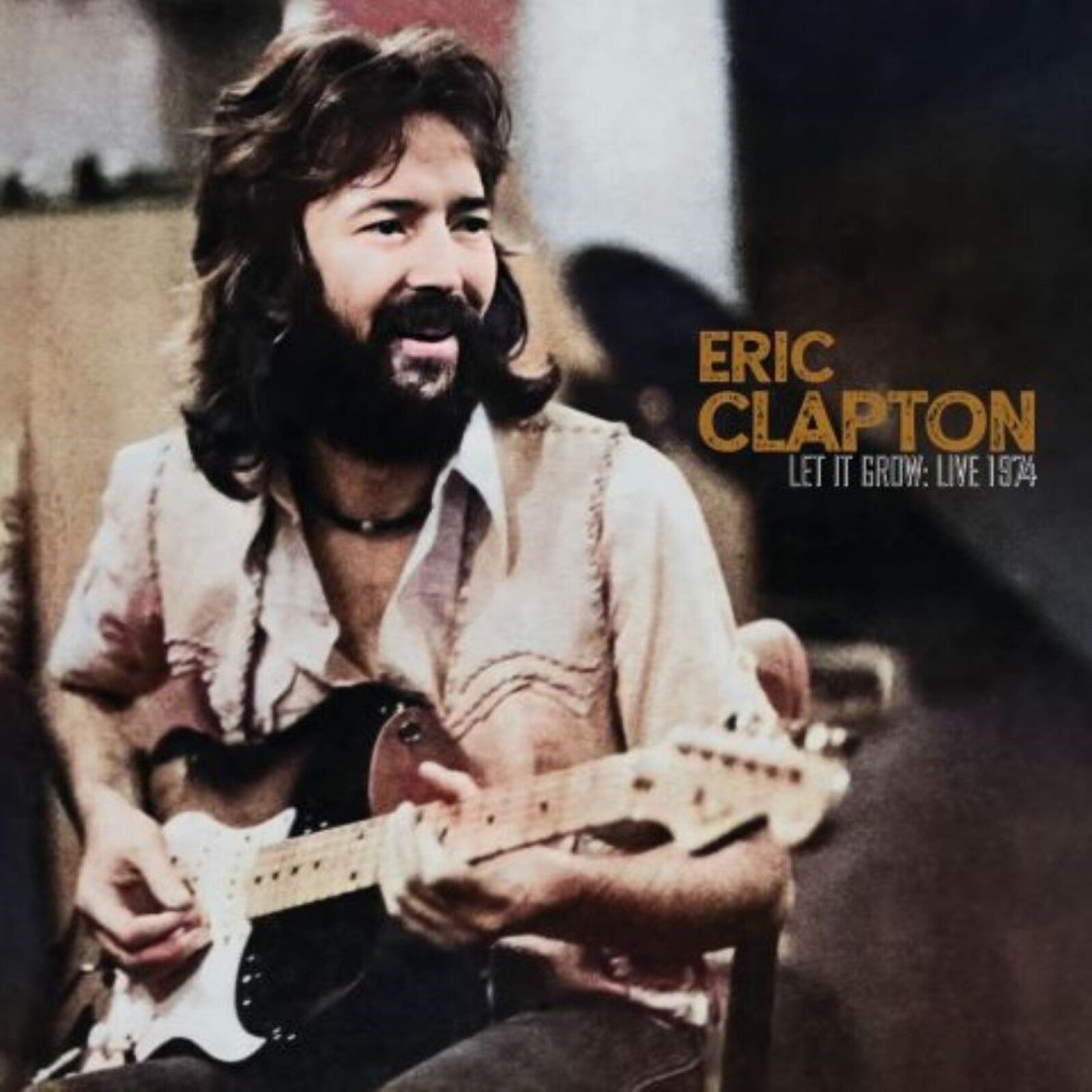 Eric Clapton with a beard and long hair playing an electric guitar in 1974.