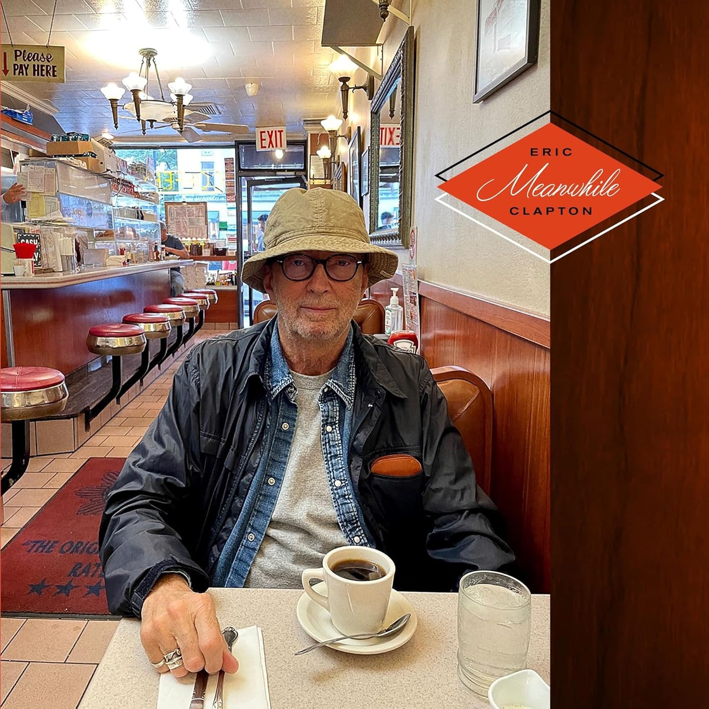 Eric Clapton’s “Meanwhile” CD cover featuring him in a diner booth.